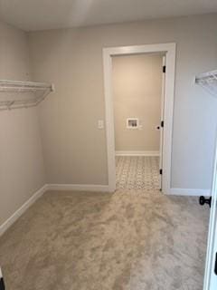 walk in closet featuring light carpet