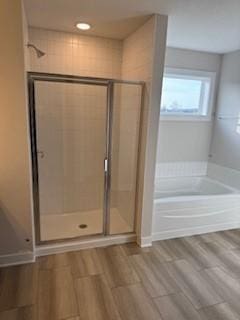 bathroom with hardwood / wood-style floors and separate shower and tub