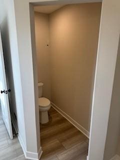 bathroom featuring wood-type flooring and toilet