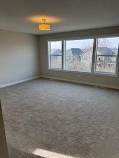 empty room featuring a wealth of natural light, carpet floors, and a mountain view