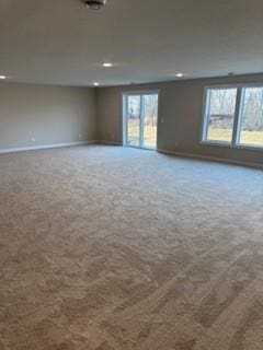 unfurnished room featuring carpet floors and a healthy amount of sunlight