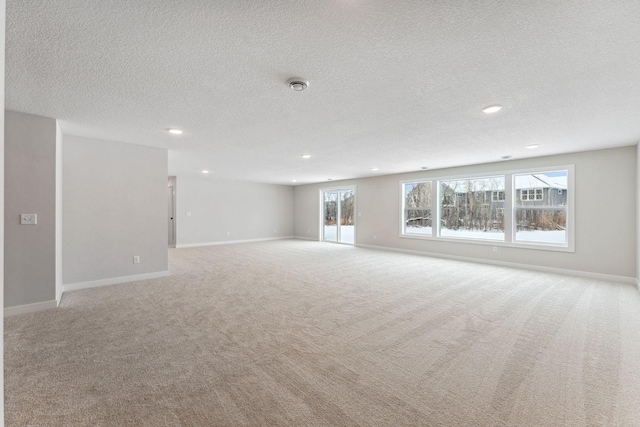 unfurnished living room featuring light colored carpet and a textured ceiling