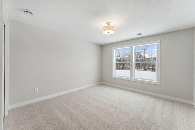 carpeted spare room with a textured ceiling