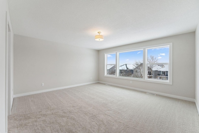 carpeted spare room with a textured ceiling