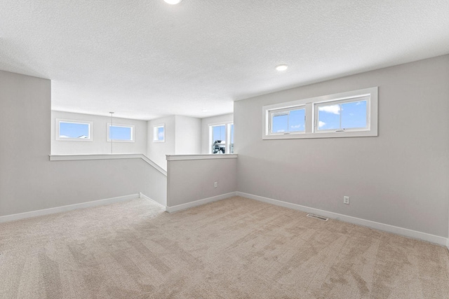 basement with light colored carpet and a textured ceiling