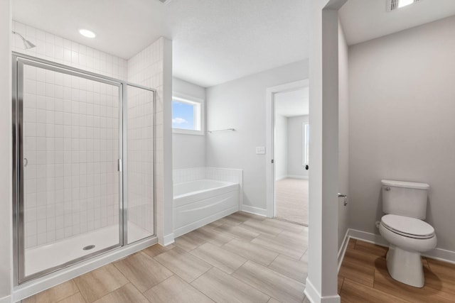 bathroom featuring separate shower and tub and toilet