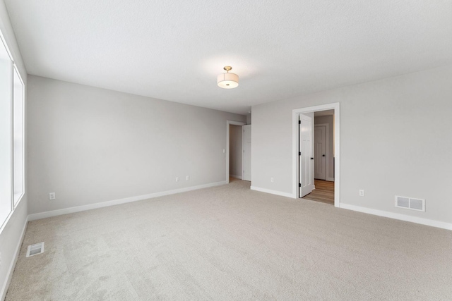 carpeted spare room featuring a textured ceiling