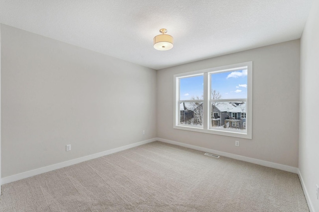 carpeted empty room featuring a textured ceiling