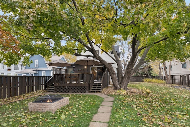 view of yard featuring an outdoor fire pit and a wooden deck