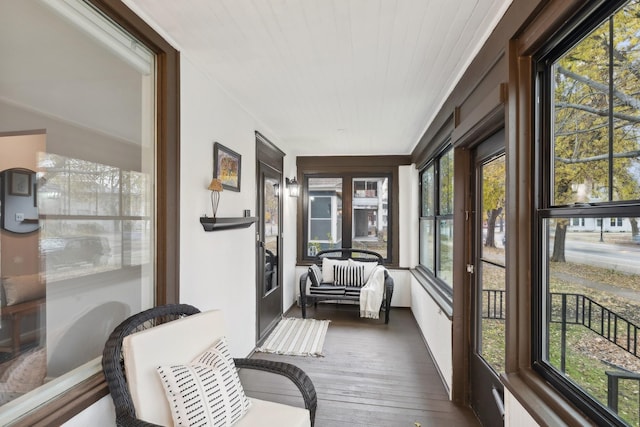 sunroom / solarium with a healthy amount of sunlight and wooden ceiling