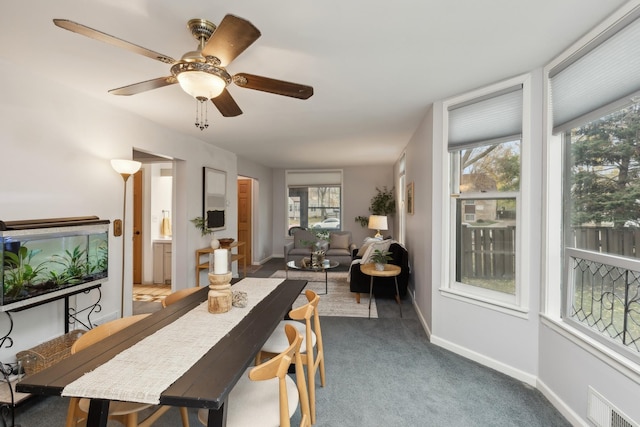 carpeted dining area with ceiling fan