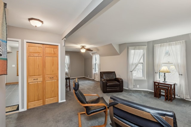 sitting room with ceiling fan and dark colored carpet