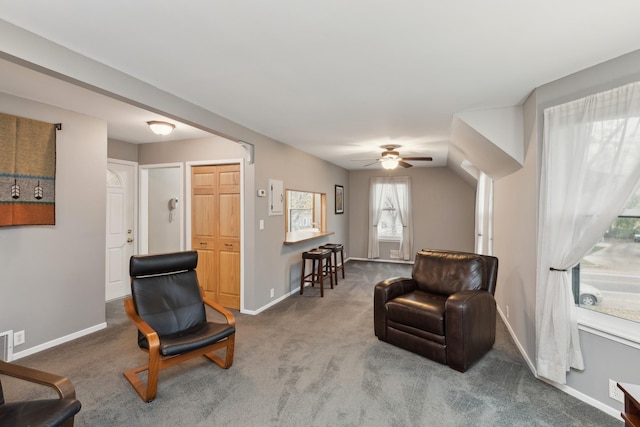 sitting room with ceiling fan and carpet