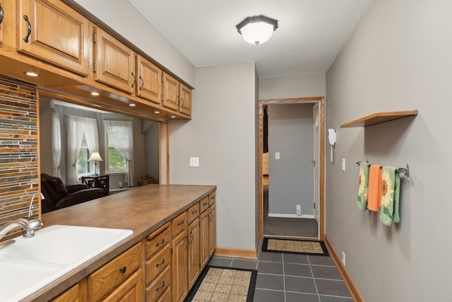 interior space with dark tile patterned floors and sink