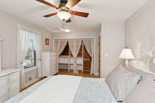 bedroom featuring light wood-type flooring, ceiling fan, and a closet