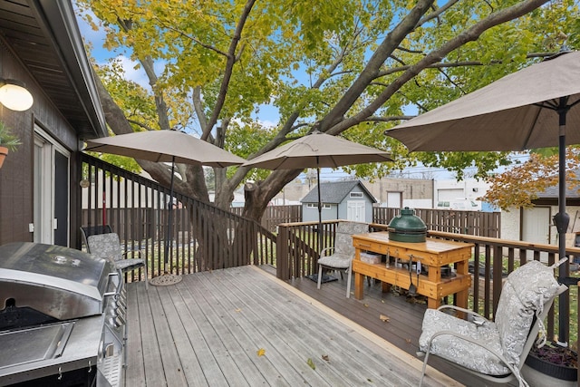 wooden deck featuring a storage unit and grilling area