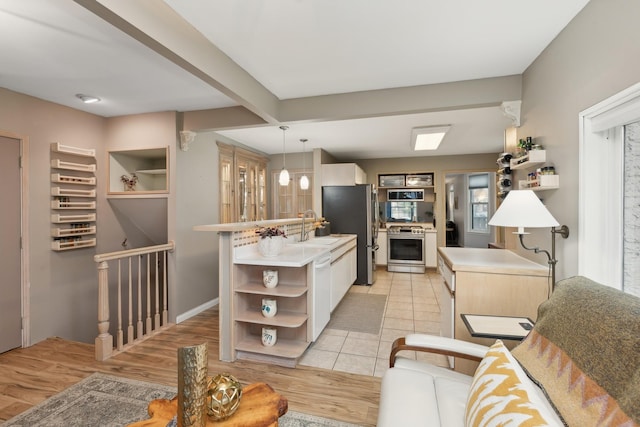 kitchen with stainless steel appliances, light hardwood / wood-style flooring, white cabinets, and decorative light fixtures