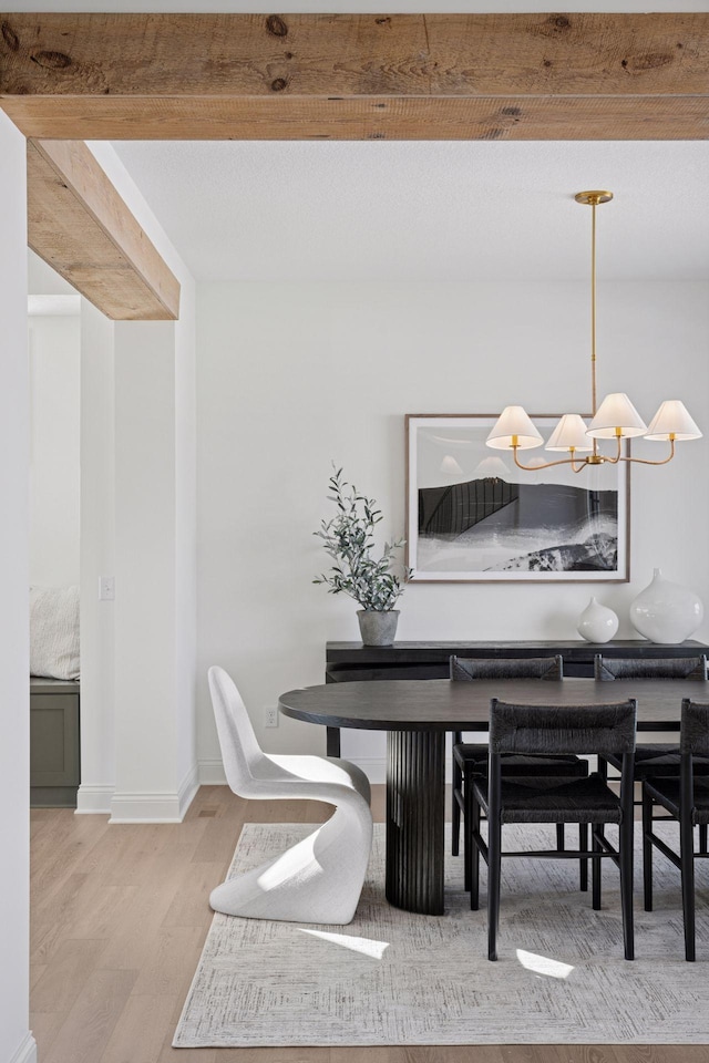 dining area with a chandelier, wood finished floors, and baseboards