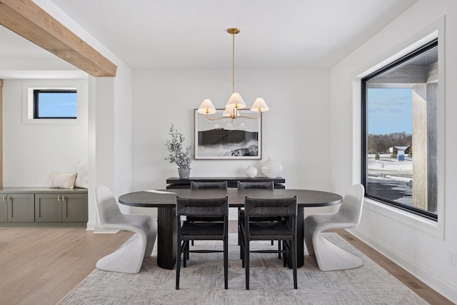 dining space featuring baseboards, an inviting chandelier, and wood finished floors