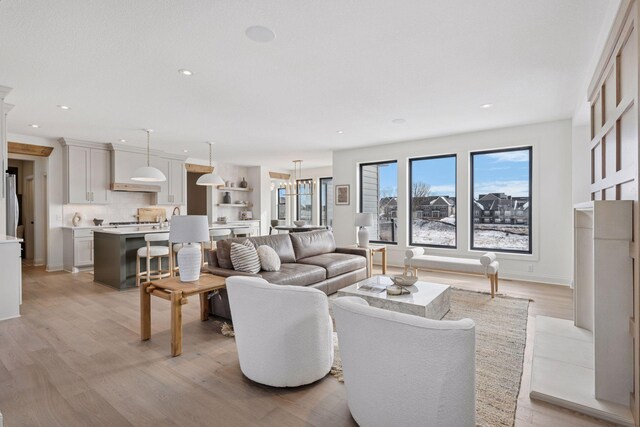 living area featuring recessed lighting, light wood-style flooring, and baseboards