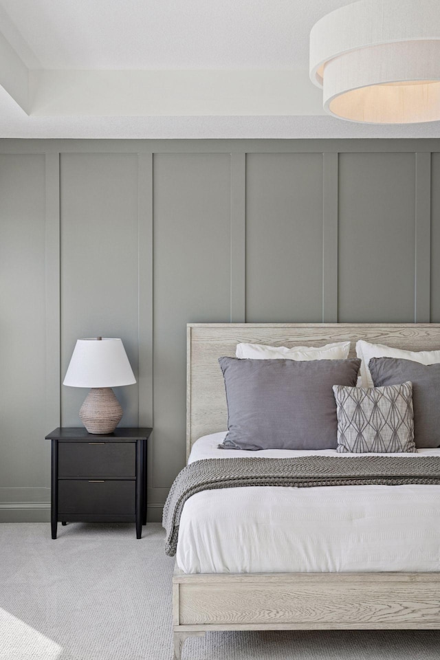 carpeted bedroom with a decorative wall