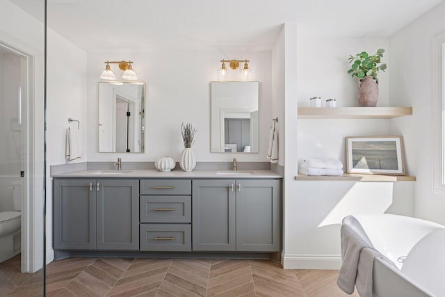 full bathroom with a sink, toilet, and double vanity