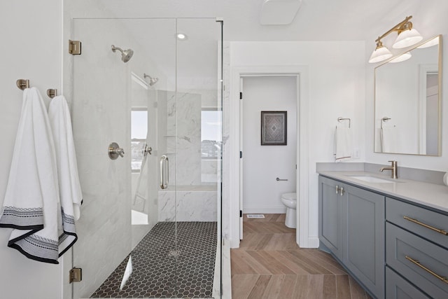 full bath featuring visible vents, toilet, a stall shower, vanity, and baseboards