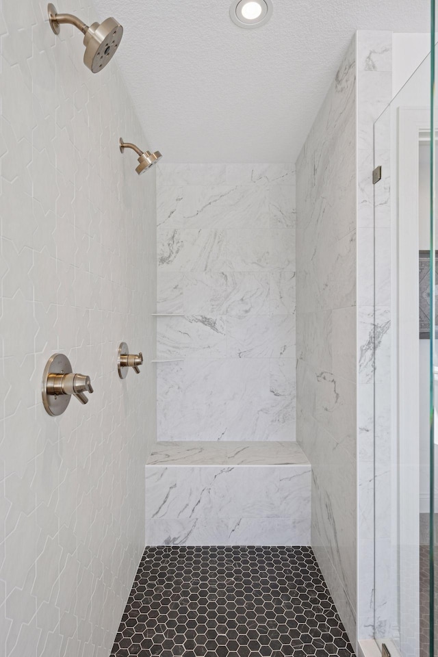 bathroom featuring a shower stall and a textured ceiling