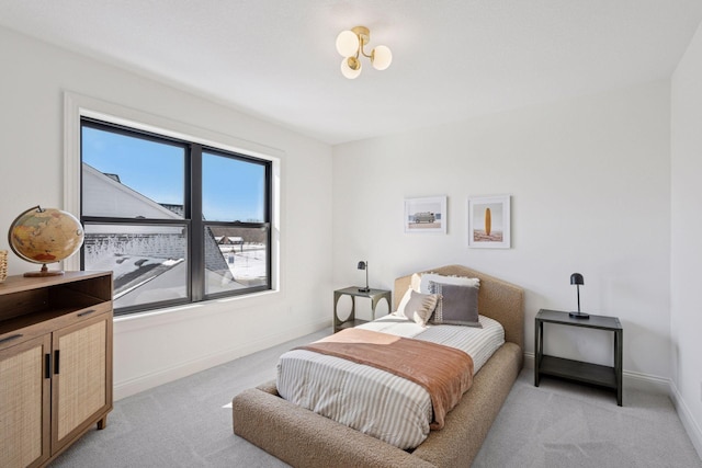 bedroom featuring baseboards and light colored carpet