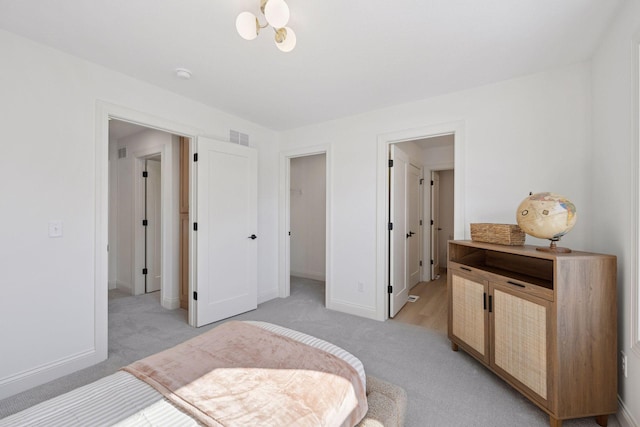 bedroom with baseboards, visible vents, and light colored carpet