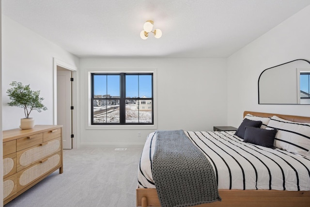 bedroom featuring light carpet and baseboards