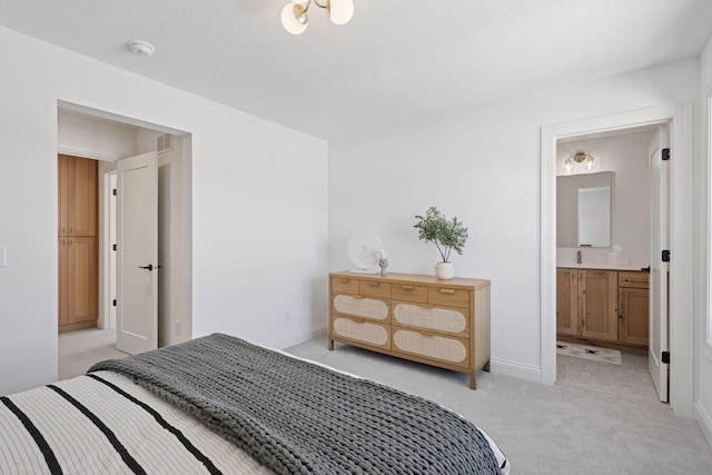 bedroom with light colored carpet, ensuite bath, visible vents, and baseboards