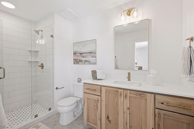 bathroom with a shower stall, toilet, and vanity