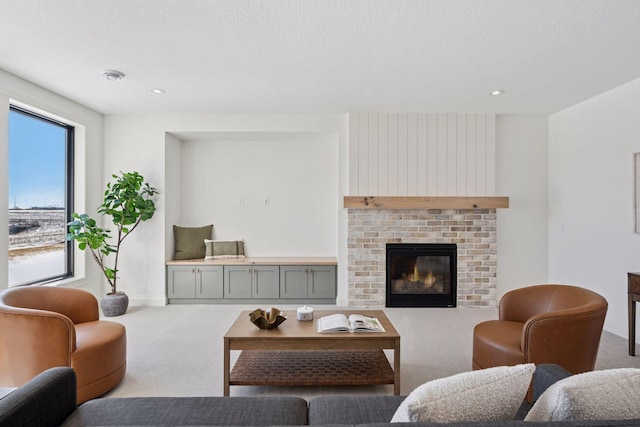 carpeted living room with a textured ceiling, recessed lighting, a brick fireplace, and baseboards