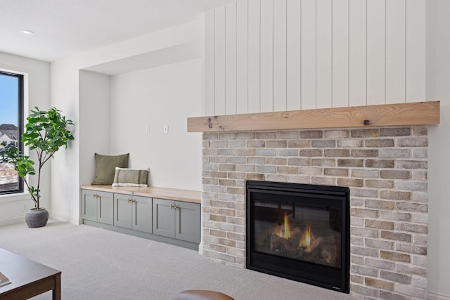 living room featuring carpet floors, a brick fireplace, and baseboards