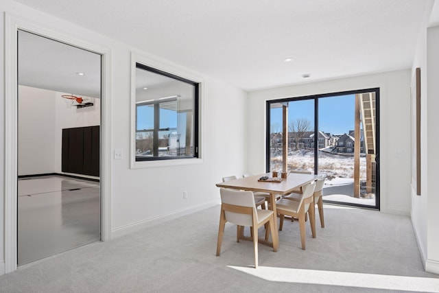 carpeted dining area featuring baseboards