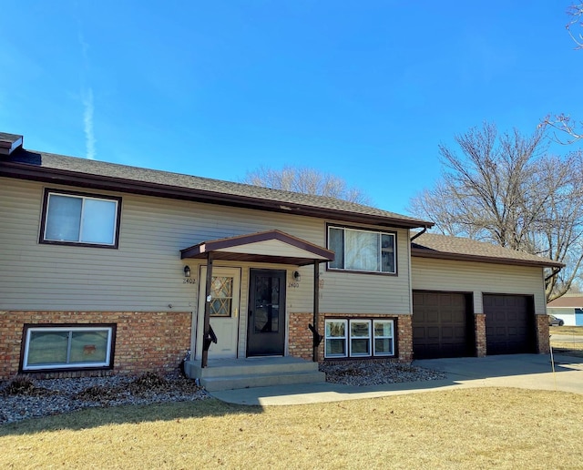 2402 Kenwood Dr SW, Willmar, MN 56201 - bi-level home with a garage, brick siding, concrete driveway, and a front lawn