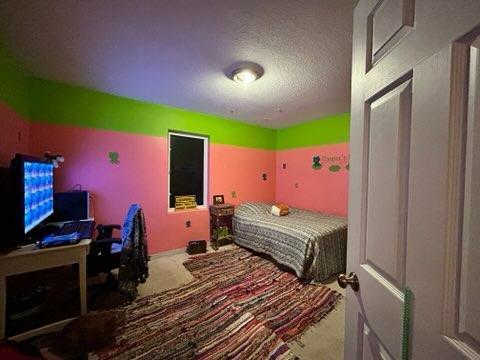 bedroom featuring carpet and a textured ceiling