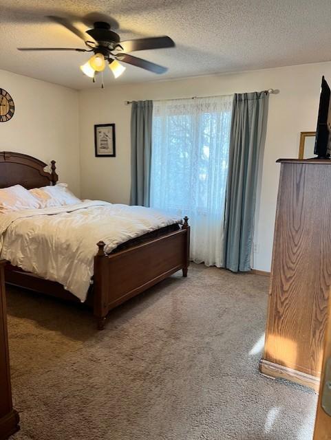 bedroom with ceiling fan and a textured ceiling