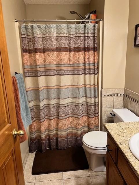 bathroom featuring a textured ceiling, toilet, vanity, and tile walls