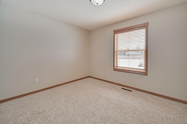 carpeted spare room with a textured ceiling