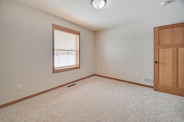 carpeted spare room with a textured ceiling