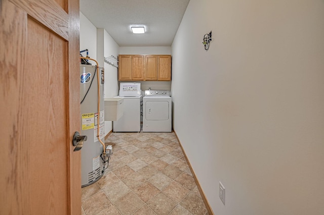 clothes washing area featuring water heater, a textured ceiling, cabinets, and independent washer and dryer