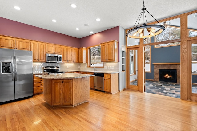 kitchen featuring sink, a center island, stainless steel appliances, and a healthy amount of sunlight