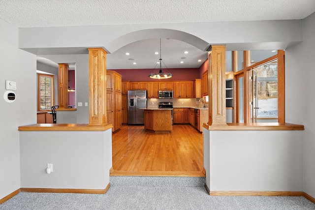 kitchen with sink, stainless steel appliances, a healthy amount of sunlight, and pendant lighting