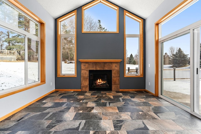 sunroom featuring a tile fireplace and lofted ceiling