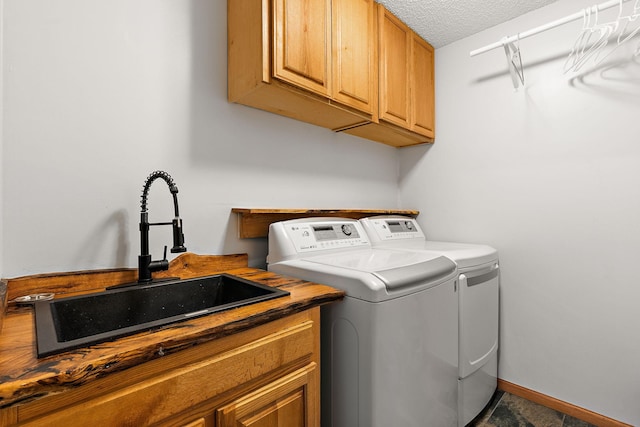 washroom with cabinets, sink, a textured ceiling, and independent washer and dryer