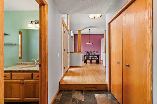 hallway with sink and a textured ceiling