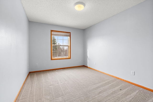 carpeted spare room featuring a textured ceiling