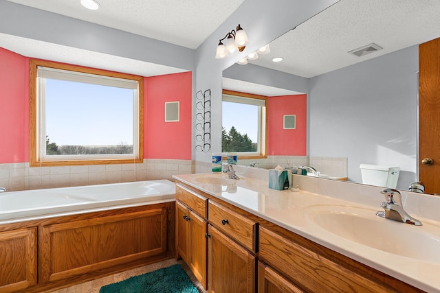 bathroom featuring a textured ceiling, toilet, and a healthy amount of sunlight